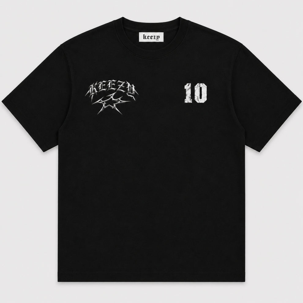 A black short-sleeve crewneck t-shirt with a white distressed graphic on the left chest reading 'KEEZY' and a '10' on the right chest, shown flat against a light gray background. JUDE 