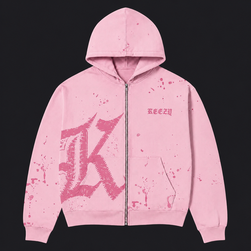 A pink zip-up hoodie with a distressed, splattered design, featuring a large stylized 'K' graphic on the front, a small 'KEEZY' logo on the chest, and a front kangaroo pocket, shown against a solid black background.