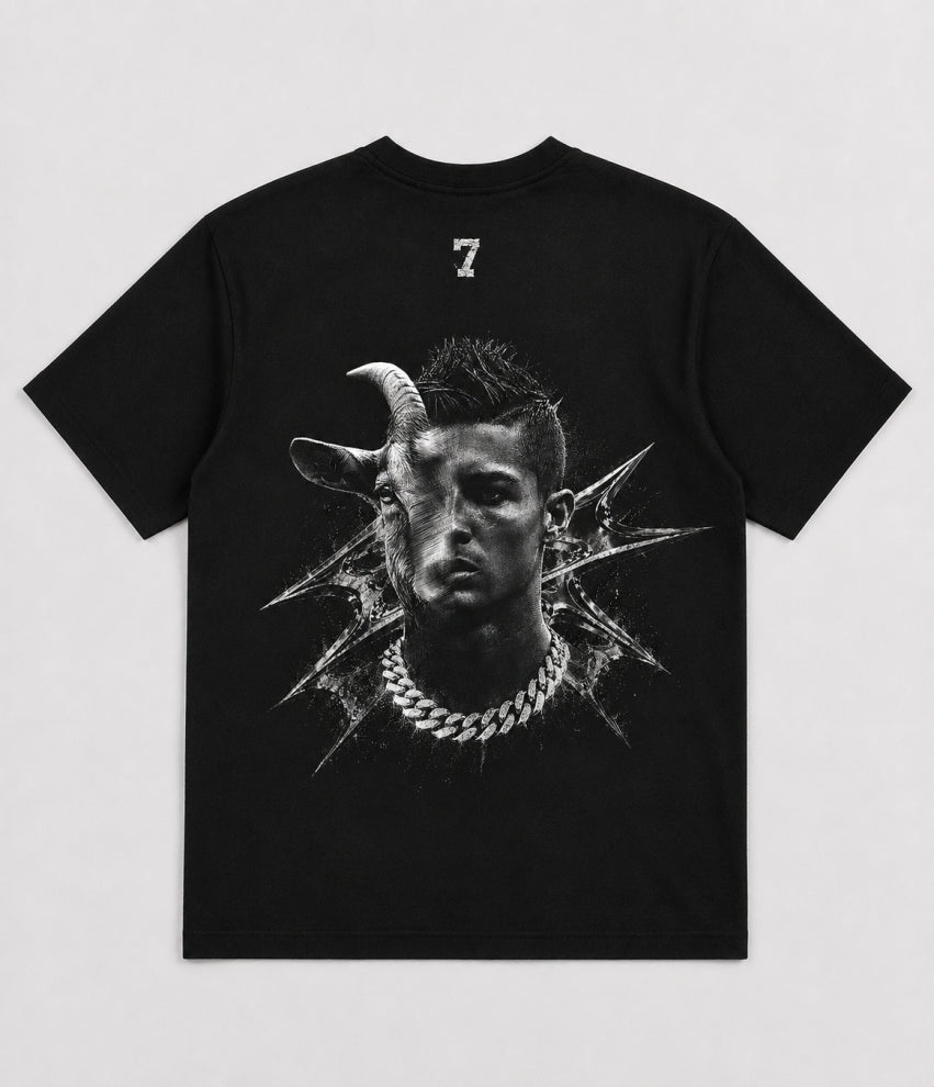 A black short-sleeve t-shirt with a large black-and-white graphic print on the front showing a stylized face with a goat horn and a silver chain necklace, with a small white number 7 printed above the collar.